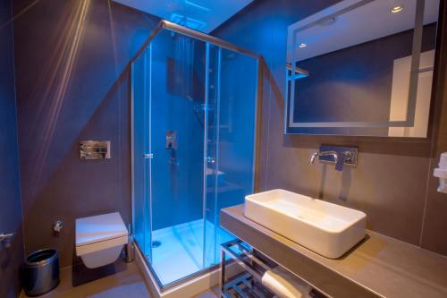 een badkamer met een wastafel en een glazen douche bij Anatolia Inn in Istanbul