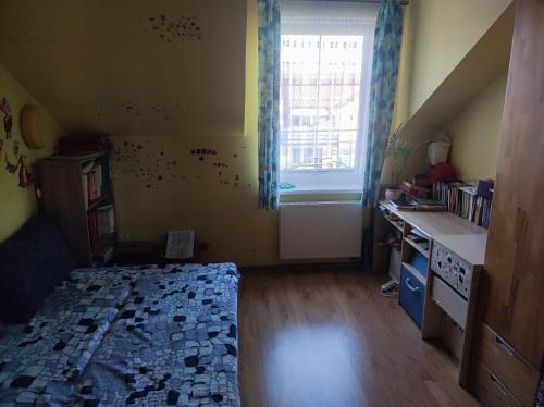 a bedroom with a bed and a desk and a window at Mieszkanie in Iława