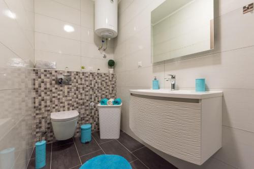 a bathroom with a sink and a toilet at Apartman Paštura in Vodnjan