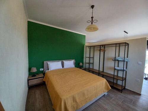 a bedroom with a green wall and a bed at Pezoulia Cottages in Samothráki