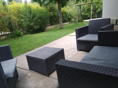 un patio con sillas y mesas negras y un patio en studio en rez-de-jardin dans la verdure, en Aix-en-Provence