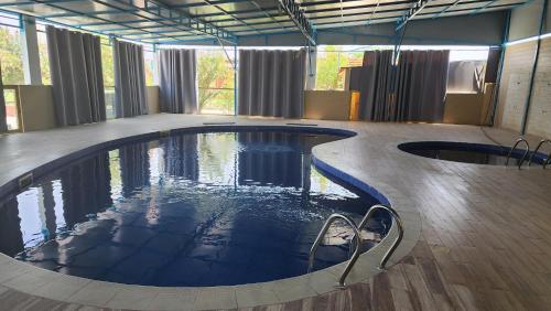 a large swimming pool in a room with windows at 4 bedroom Yasmin Garden in Barka