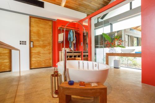 a bathroom with a large tub and red walls at Island Escape Burasari in Phuket Town