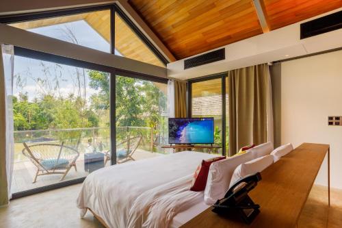 a bedroom with a large bed and a large window at Island Escape Burasari in Phuket Town