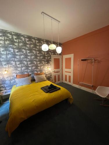 - une chambre avec un lit et une couverture jaune dans l'établissement Maison Mandarine, à Bellerive-sur-Allier