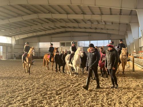 a group of people riding horses in a building at Dvůr Nové Zámky in Mladeč