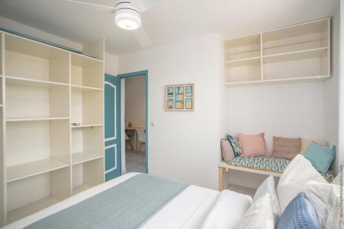 - une chambre avec un lit, un canapé et des étagères dans l'établissement Akwatik Appart 150m de la plage, à Les Trois-Îlets