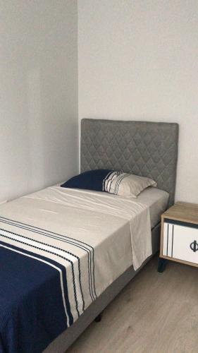 een bed met een grijs hoofdeinde en een tafel bij MY HOUSE in Yomra