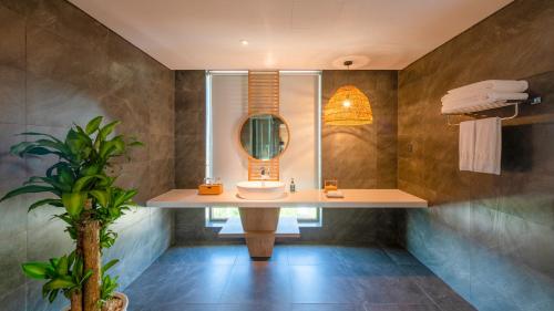 a bathroom with a sink and a mirror at Bellerive Hoi An Resort and Spa in Hoi An