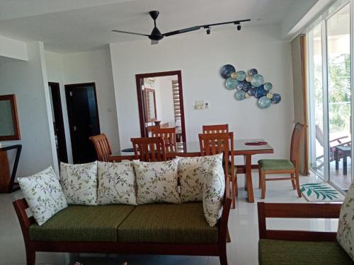 a living room with a couch and a table and chairs at Sandy Shores in Trincomalee