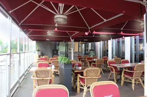 una fila de mesas y sillas en un patio en Hotel Restaurant Keizersberg, en Elsendorp