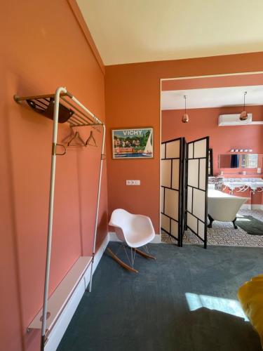 a bedroom with orange walls and a bed and a tub at Maison Mandarine in Bellerive-sur-Allier