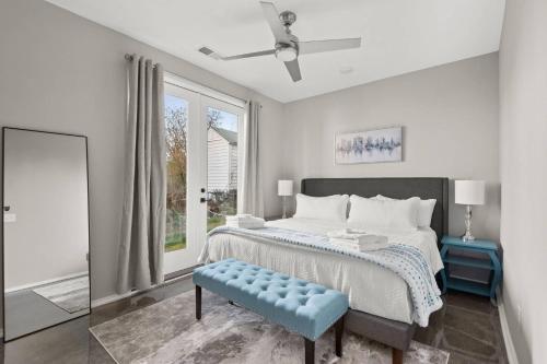 a white bedroom with a bed and a blue stool at Myrtle D in Nashville