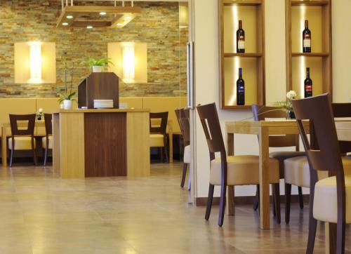 a restaurant with a table and chairs and wine bottles at Pension zur Sonne in Illmitz
