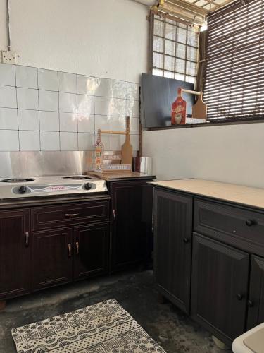 a kitchen with wooden cabinets and a stove top oven at Homestay Vista3A at Vista Seri Putra in Kajang