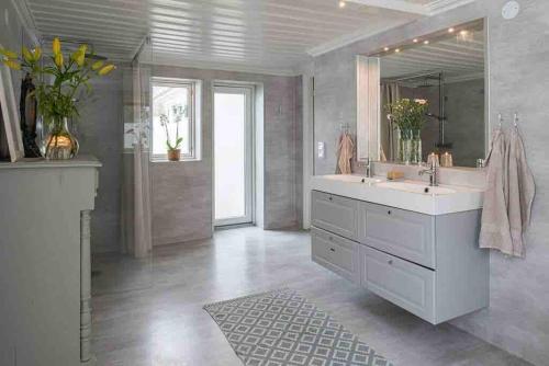 uma casa de banho com um grande lavatório e um espelho em Big house with jacuzzi by the forrest em Hudiksvall