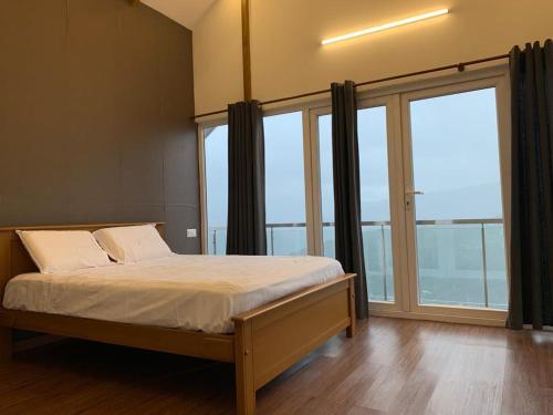 a bedroom with a bed and a large window at Cuckoos Nest in Vagamon
