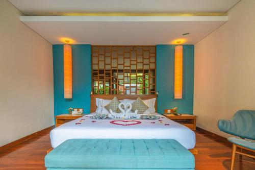 1 dormitorio con 1 cama grande y paredes azules en Maca Villas and Residence Umalas, en Seminyak