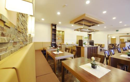 a restaurant with wooden tables and chairs and a bar at Pension zur Sonne in Illmitz
