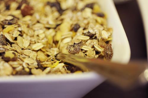 a close up of a bowl of granola with a spoon at Pension zur Sonne in Illmitz