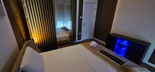 a room with a bed and a tv and a window at Lux Apartmani Novi Park in Vrdnik