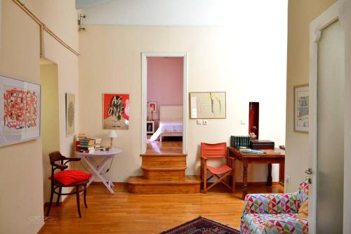 ein Zimmer mit einem Wohnzimmer mit einem Tisch und Stühlen in der Unterkunft At the foot of Acropolis. in Athen