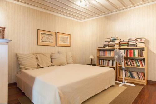 1 dormitorio con 1 cama y estantería con libros en At the foot of Acropolis. en Athens