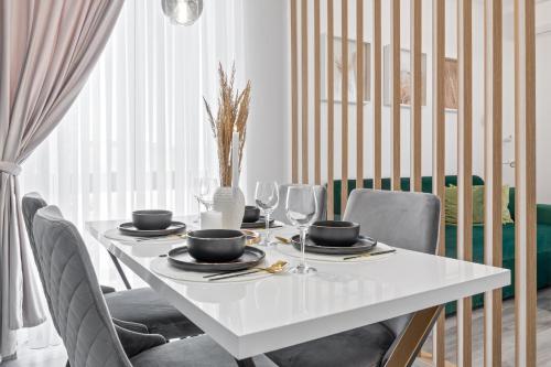 a white table with chairs and a white table with glasses at Felix Flat in Baile Felix