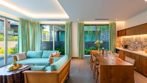 a living room with a blue couch and a table at Bellerive Hoi An Resort and Spa in Hoi An