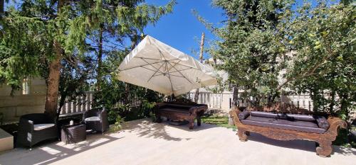 a patio with two couches and an umbrella at Faqra Palace in Kfardebian