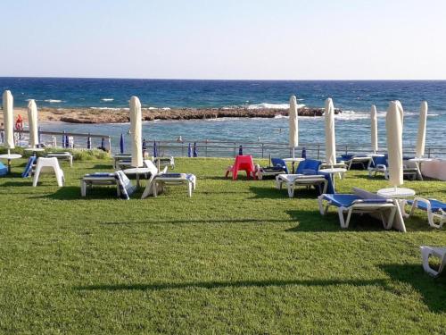 a group of chairs and tables on the beach at Yama's Villa - Polyxenia luxury, protaras, cyprus in Protaras