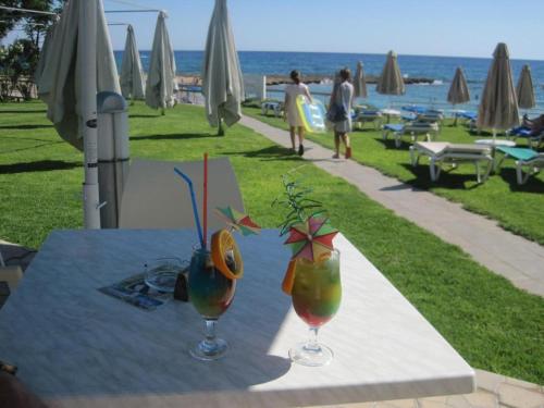 two cocktails sitting on a table with a view of the ocean at Yama's Villa - Polyxenia luxury, protaras, cyprus in Protaras