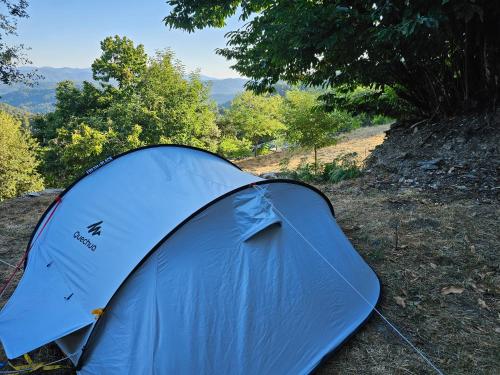 a blue tent sitting on the side of a hill at Camping à la ferme in Saint-Germain-de-Calberte