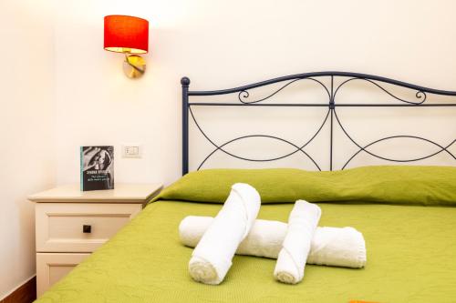 a bedroom with a green bed with towels on it at Agriturismo I Tesori del Sud Vieste, Puglia in Vieste