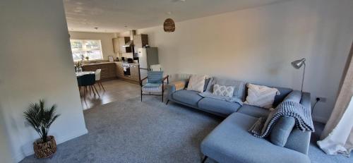 Una sala de estar con un sofá azul y una cocina. en Cashel on the Coast, 3 bedroom holiday home, Ballycastle, en Ballycastle