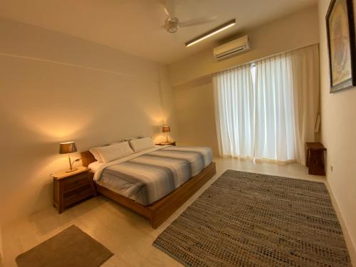 a bedroom with a bed and a large window at By The Sea @ Cozy Beachfront Home in Batu Ferringhi