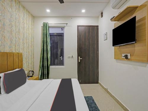 1 dormitorio con 1 cama y TV de pantalla plana en OYO Flagship Cosmo Inn en Allahābād