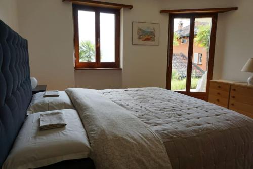 um quarto com uma cama grande e uma janela em Casa Verbanella em Minusio