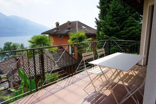 a balcony with a white table and chairs on it at Casa Verbanella in Minusio