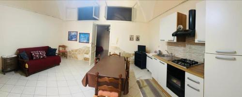 eine Küche mit einem Sofa und einem Tisch in einem Zimmer in der Unterkunft Casa in centro a Giarre in Giarre