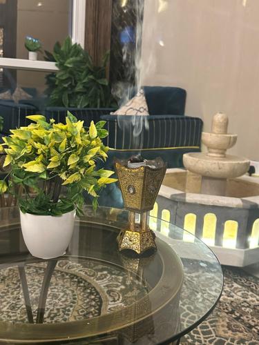 الحريرة في جدة: غرفة معيشة مع طاولة زجاجية عليها زهور