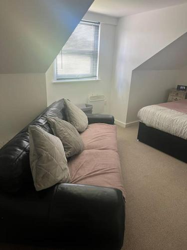 a living room with a couch and a bed at Just off the m1 and A1 apartment in Hoyland Nether