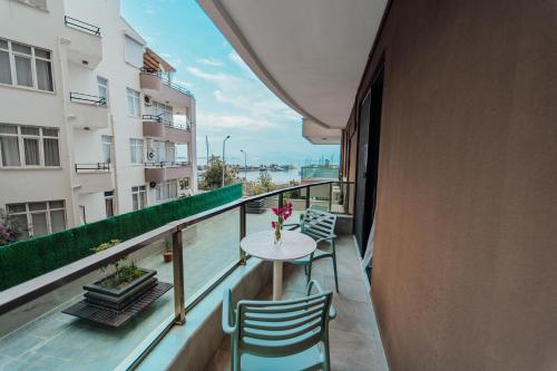 a balcony with a table and chairs on a building at Fortunella Suites in Finike