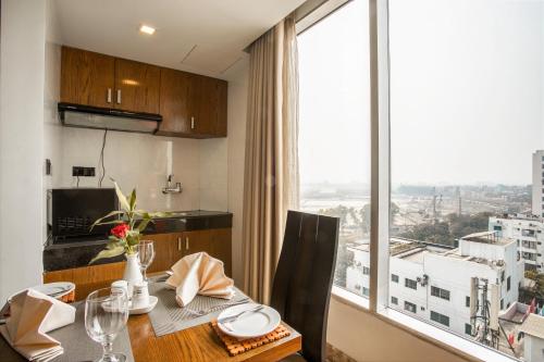 a kitchen with a table and a large window at Marino Royal Hotel in Dhaka