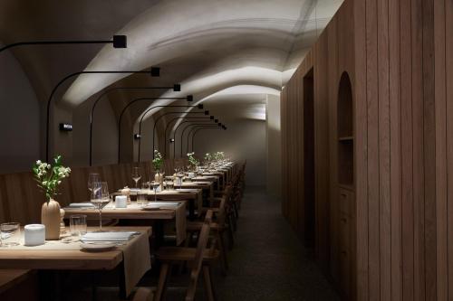 una lunga sala da pranzo con tavoli e sedie lunghi di fink Restaurant & Suites a Brixen