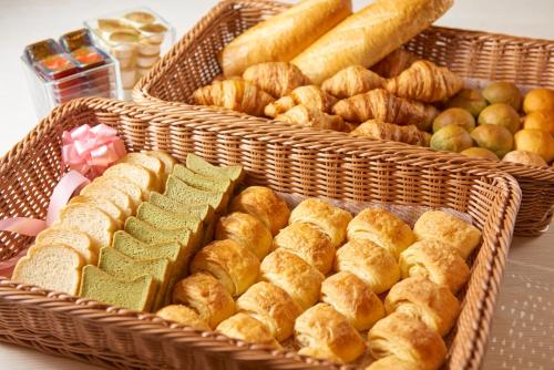 two baskets filled with bread and pastries on a table at Osaka Tokyu REI Hotel in Osaka