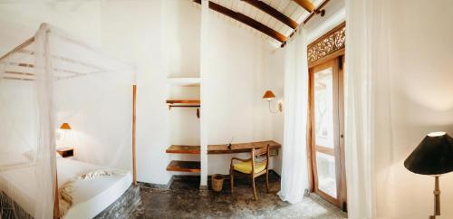 a bedroom with a bed and a desk in a room at Amuura Beach Villa in Beruwala