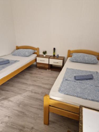 a room with two beds and two night stands at Visit Drežnica in Mostar