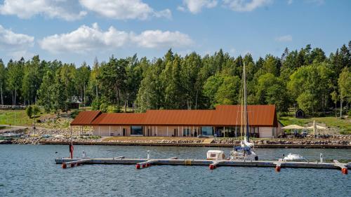 a house on the water with a dock and a boat at Hara sadama kalurihütt 