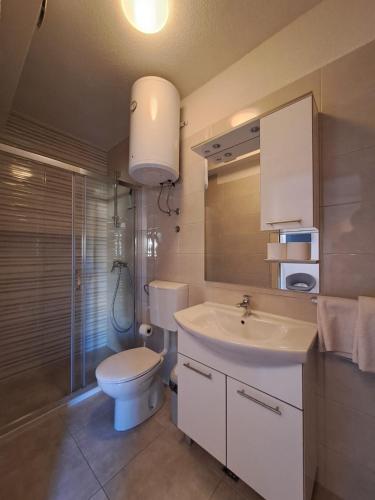 a bathroom with a white sink and a toilet at Apartments Ostojic in Tučepi